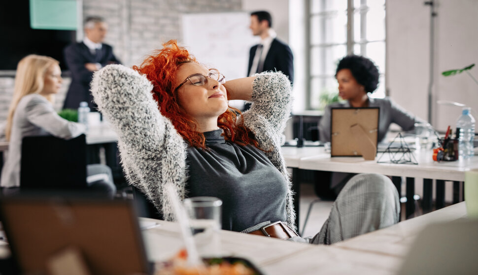 Happy businesswoman relaxing with eyes closed in the office.